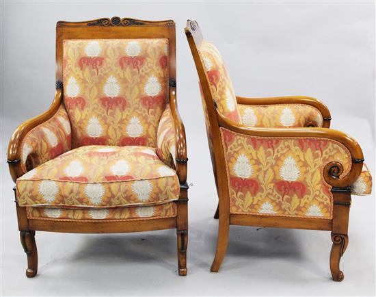 A pair of French Empire style parcel ebonised beech fauteuils,